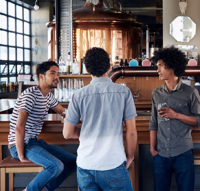 three friends enjoying drinks and company at a local brewery