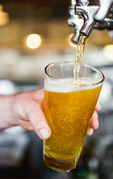 a bartender filling a glass of beer from a tap