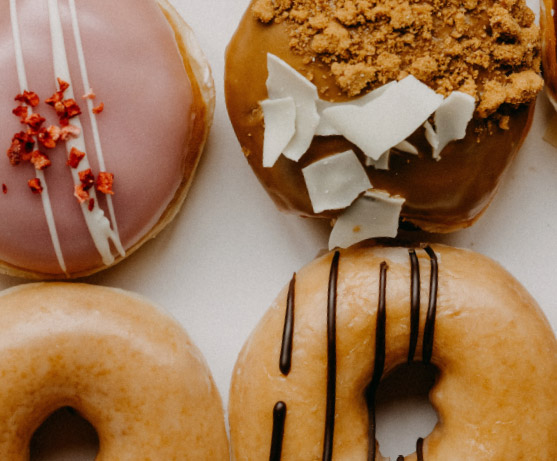 four tasty artisinal doughnuts in a to-go box